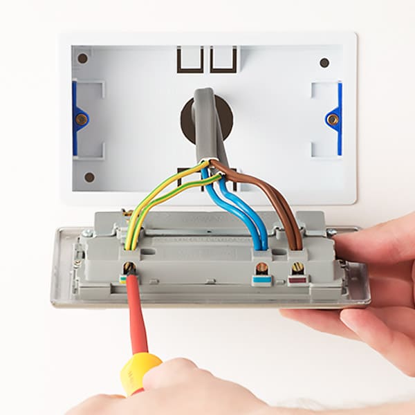 electrician installing electrical wall outlets