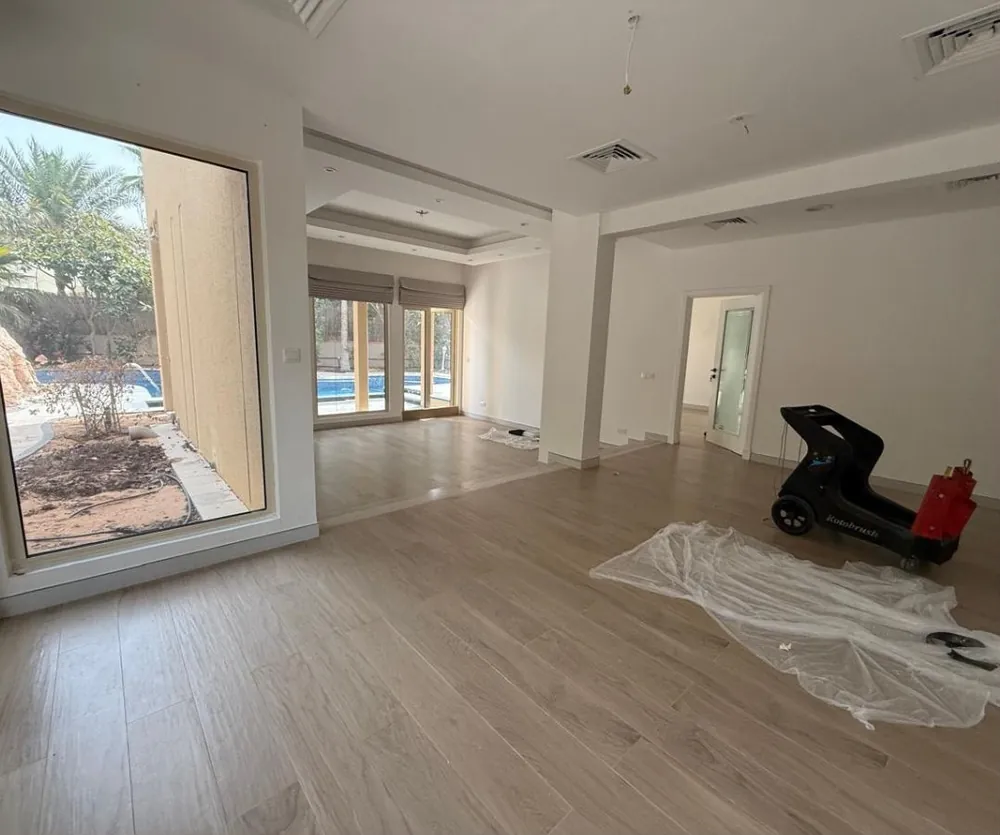 Before: empty dining area in an Arabian Ranches villa with wood-look floor and garden window
