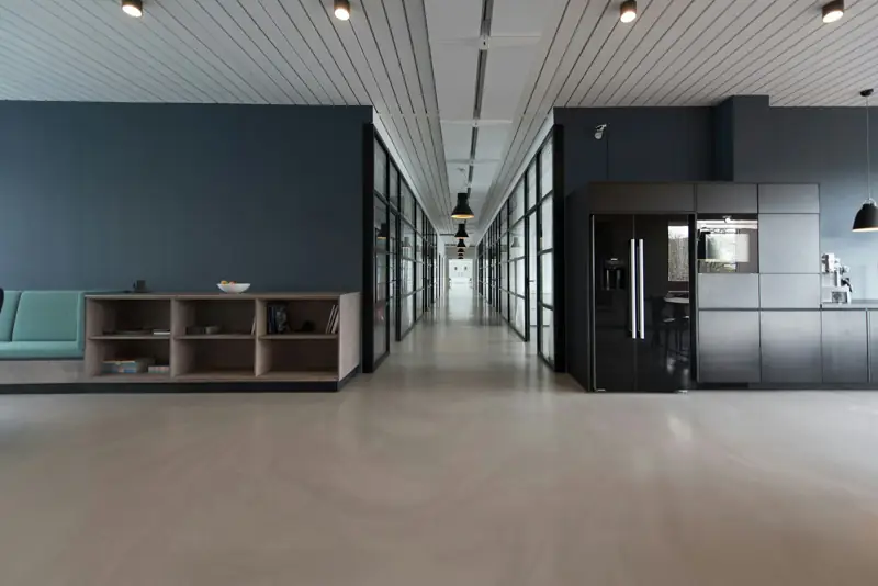 Open-plan office with glass partitions and a long corridor
